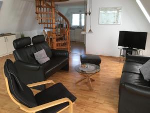 Bünsdorf的住宿－Aukamp，客厅配有黑色真皮沙发和桌子