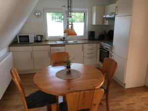 Bünsdorf的住宿－Aukamp，一个带木桌和椅子的小厨房
