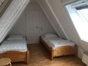 two beds in a small room with two windows at Aukamp in Bünsdorf
