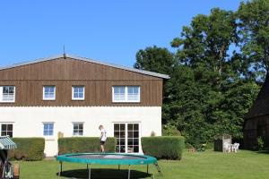 a person standing on a trampoline in front of a house at Ferienwohnung 7, OG, Hof zur Sonnenseite Fehmarn in Fehmarn