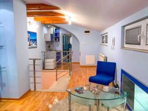 a living room with a blue chair and a glass table at Lux Villa Mitimago in Niš