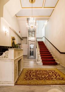 a hallway with a staircase and a chandelier at Palaiologos Luxury City Hotel in Patra