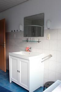 ハイリゲンハーフェンにあるFerienwohnung "Strand Hus 1"のバスルーム(白い洗面台、鏡付)