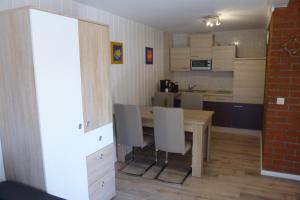 uma pequena cozinha com uma mesa de madeira e cadeiras em Heublein em Poseritz