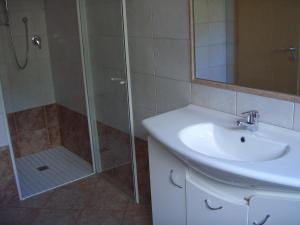 een badkamer met een douche, een wastafel en een douche bij Ferienwohnung im Haus Texel V in Rablà