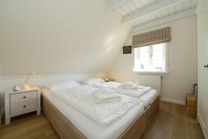 ヴィーク・アウフ・フェールにあるHaus Strandburgのベッドルーム1室(白いシーツ付きのベッド1台、窓付)