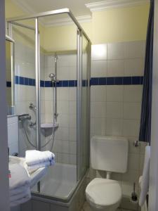 La salle de bains est pourvue d'une douche, de toilettes et d'un lavabo. dans l'établissement FeWo J 24, à Laboe