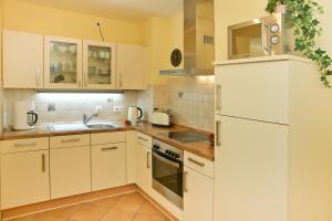 cocina con armarios blancos y nevera blanca en Ferienwohnung Oase102, en Kühlungsborn