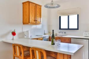 a kitchen with a white counter top and wooden cabinets at Tavros Hotel Apartments in Polis Chrysochous