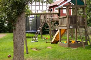 a playground with a tree house and a slide at Hof Timmermann - Landhaus, oben in Ottenstein