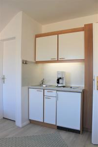 a kitchen with white cabinets and a sink at Haus Barbara - Schwimmbad und Sauna im Haus- Whg 5 in Grömitz