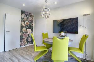 a dining room with a table and green chairs at Seelavie in Zingst