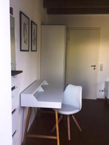 a white desk and a white chair in a room at Gscheidles Ferienwohnung 40 munterm Haigern Talheim in Talheim