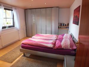 um quarto com uma cama com lençóis cor-de-rosa e brancos em Ferienwohnung Iris em Fritzlar