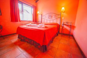 a red bedroom with a bed with a red blanket at Hotel Campanilla in Ushuaia
