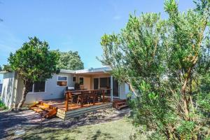 a home with a deck with a table and benches at 150 Steps FREE WI-FI in Apollo Bay