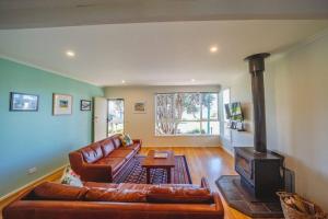 a living room with a couch and a wood stove at 150 Steps FREE WI-FI in Apollo Bay