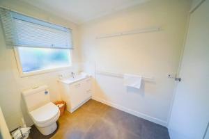 a bathroom with a toilet and a glass shower at 150 Steps FREE WI-FI in Apollo Bay +22 photos