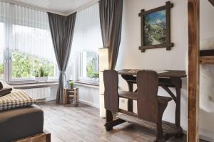 - une chambre avec un bureau et une table dans l'établissement Fewo Bubenberg, à Bad Berleburg