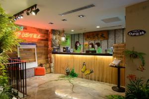 a bar in a restaurant with a woman standing at the counter at Hualien Wow Hostel in Hualien City