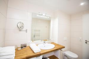 a bathroom with a sink and a toilet and a mirror at Ferienwohnung PlauOase in Plau am See