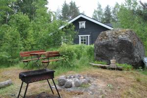 a picnic table and bench in front of a house at Kallioranta Cottage in Ruokolahti