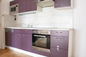 een keuken met paarse kasten en een fornuis bij Royal 4 Trend by Alpenidyll Apartments in Liezen