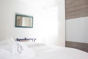 a bedroom with a bed with white sheets and a mirror at Royal 4 Trend by Alpenidyll Apartments in Liezen