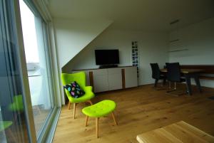a living room with green chairs and a table at Pfänder in Bettnau