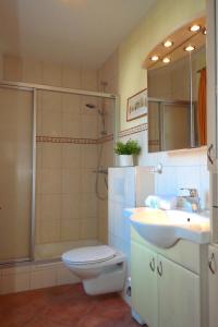 ein Bad mit einem WC, einem Waschbecken und einer Dusche in der Unterkunft Haus Hansen - Wyk Whg 01 in Wyk auf Föhr