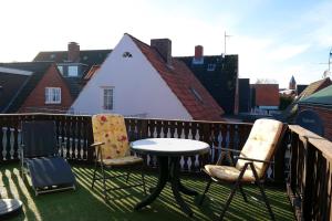 eine Terrasse mit Stühlen und einem Tisch auf dem Balkon in der Unterkunft Haus Hansen - Wyk Whg 01 in Wyk auf Föhr