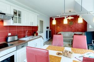 uma cozinha com uma mesa e cadeiras cor-de-rosa numa cozinha em Villa Arielle, FW 8 em Zingst