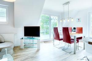 uma sala de estar com uma mesa de jantar e uma televisão em Villa Arielle, FW 8 em Zingst
