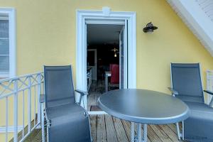 uma mesa e cadeiras numa varanda com uma mesa e cadeiras em Villa Arielle, FW 8 em Zingst