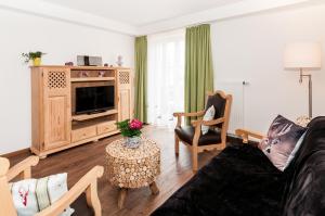 sala de estar con sofá y TV en Hirschberg en Bad Wiessee