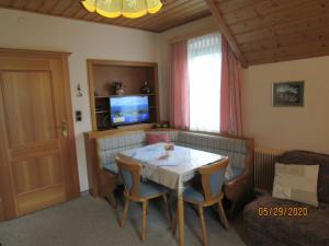 a living room with a table with chairs and a television at Villa Löcker 3 in Mariapfarr