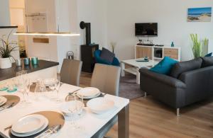 a living room with a table with plates and glasses on it at Ostsee - Appartement Nr 87a "Strandkorb" im Strand Resort in Heiligenhafen