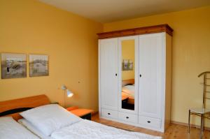 a bedroom with a white cabinet and a bed at Meeresrauschen - direkt am Meer in Staberdorf