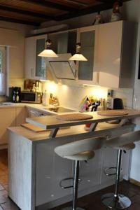 a kitchen with two bar stools at a counter at Ferienhaus 008 in Tossens in Stick