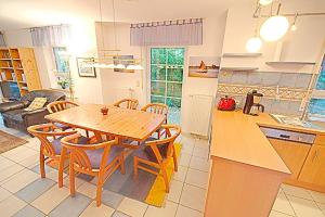 una cucina e una sala da pranzo con tavolo e sedie in legno di Seeadler a Zingst