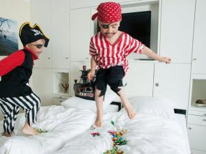 two young boys jumping on top of a bed at ancora Marina Haus 1 Nr 04, Typ 2 in Neustadt in Holstein