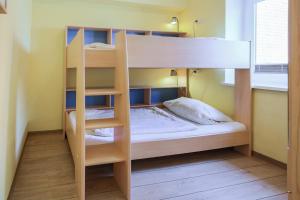 SahrensdorfにあるFerienhof Büdlfarm - Treckerschuppenの二段ベッドが備わる小さな客室のベッド1台分です。