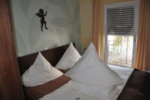 a bedroom with a bed with white pillows and a window at die Stimmungsvolle in Willingen