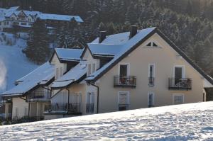 a building with snow covered roofs on a snowy hill at die Stimmungsvolle in Willingen