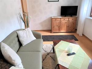 a living room with a couch and a tv at Haus Uschi - Ferienhaus in Cismar