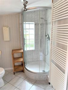 a bathroom with a shower with a glass door at Haus Uschi - Ferienhaus in Cismar