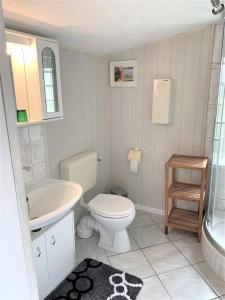 a white bathroom with a toilet and a sink at Haus Uschi - Ferienhaus in Cismar