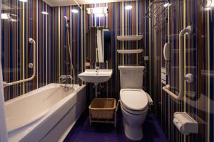 a bathroom with a toilet, tub, sink and shower at Hotel Monterey Kyoto in Kyoto