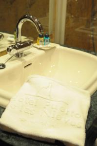 La salle de bains est pourvue d'un lavabo et d'une serviette blanche. dans l'établissement Hotel Puerto de Las Nieves, à Agaete