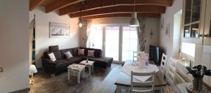 ein Wohnzimmer mit einem Sofa und einem Tisch in der Unterkunft Dat Onnens Hus - Burhave 03 in Butjadingen